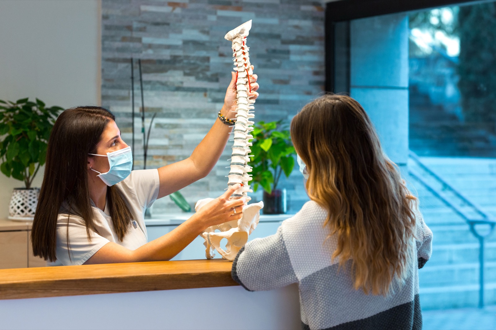Female doctor showing a spine model to a patient